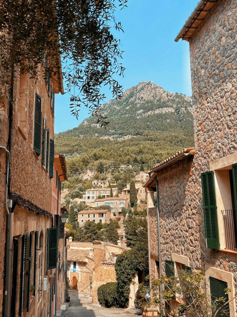 Picturesque village street with traditional stone houses and mountain views in Mallorca, Spain.